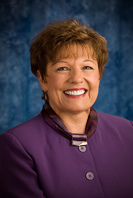 Close-up of smiling woman in purple shirt