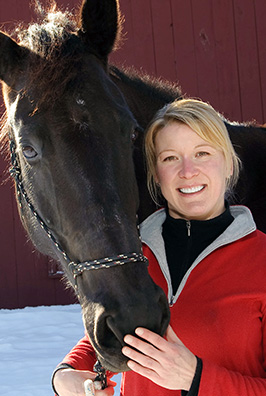 Woman in red jacket petting a horse