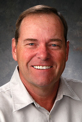 Smiling man in white collared shirt