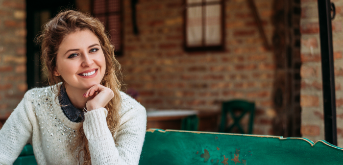 Woman sitting on green couch smiling