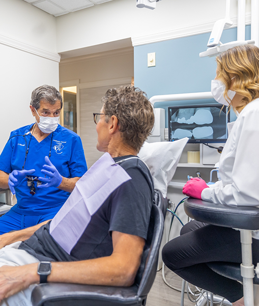 Male dental patient looking away and talking to dentist