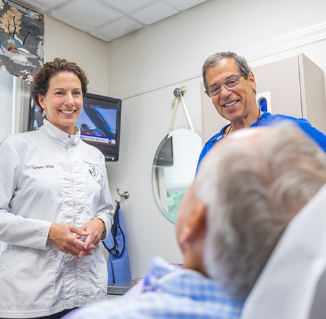 Dentist and dental team member smiling at patient