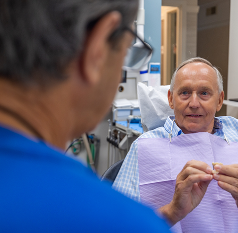 Older male dental patient looking at dentist