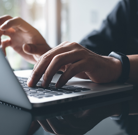 Close-up of man typing on a laptop