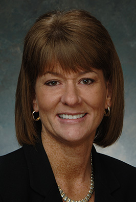 Dark-haired smiling woman with necklace