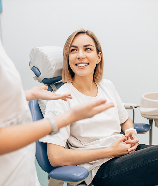 Blonde dental patient smiling at dentist