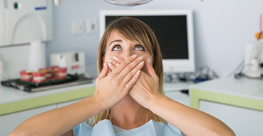 Woman covering her mouth and looking up