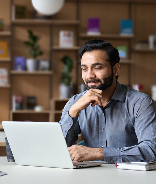 Man sitting on table looking at laptop